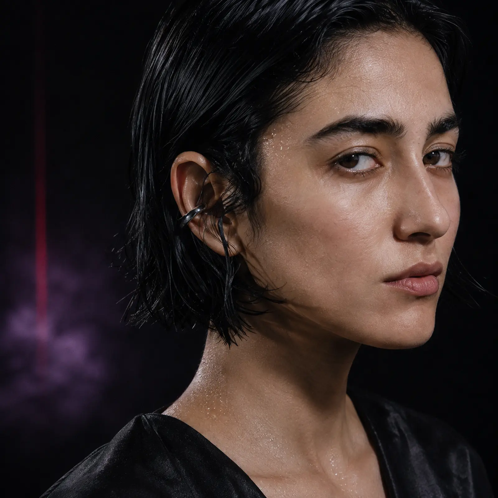 Close portrait of Mira Silt with damp black hair and an oxidised-silver ear cuff.